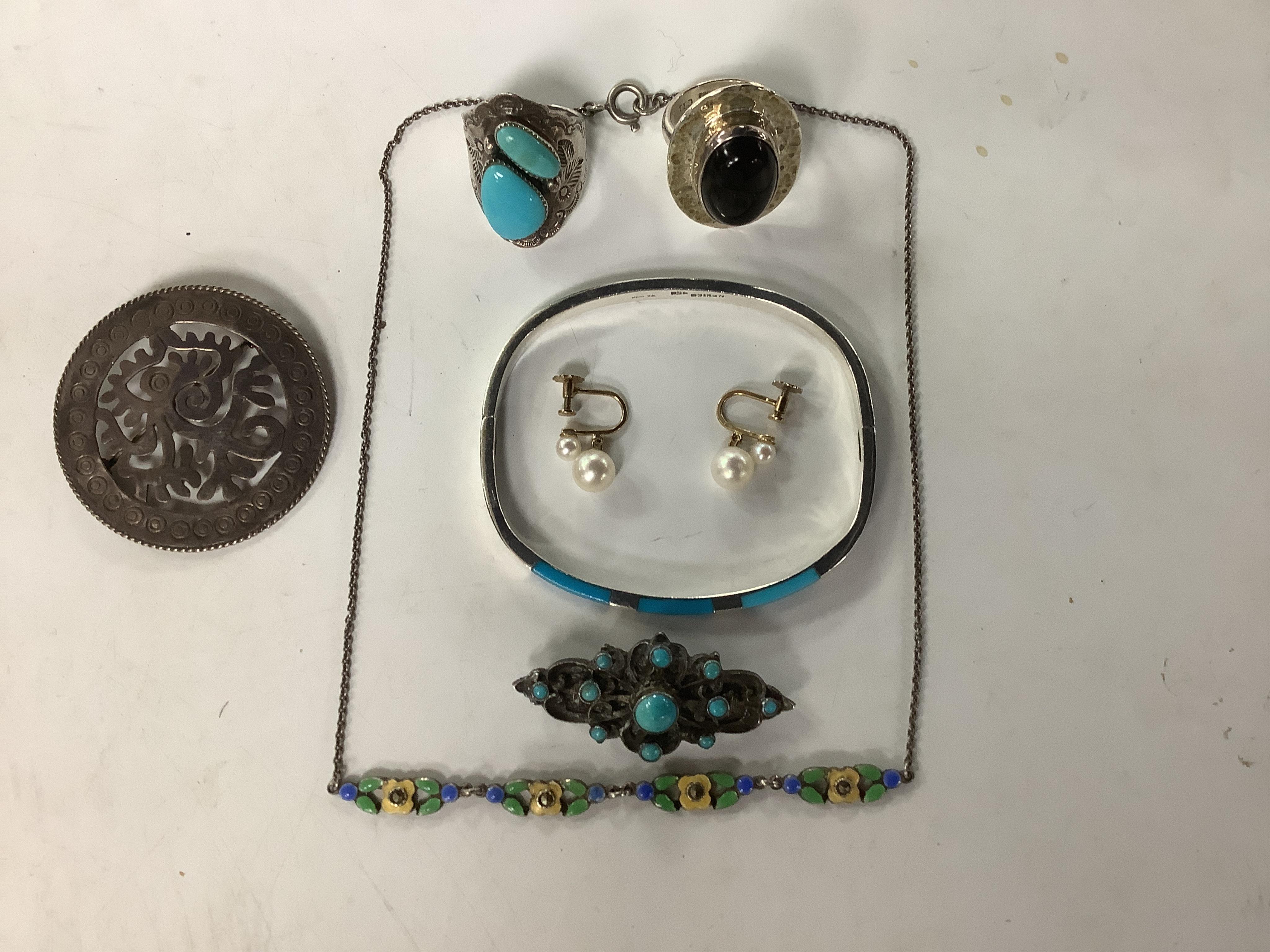 A modern Mexican silver and blue enamel hinged bangle, together with a white metal (stamped silver) and turquoise cluster set brooch, a white metal and two stone turquoise set ring, a 925 and cabochon set ring, a Mexican